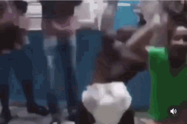 a group of people are dancing in a room in a blurry photo .