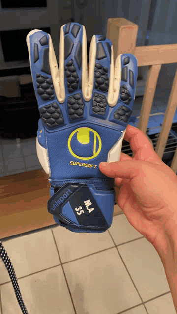 a person is holding a pair of blue gloves that say uhlsport on it