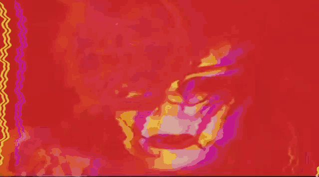 a close up of a woman 's face with red hair and black makeup .