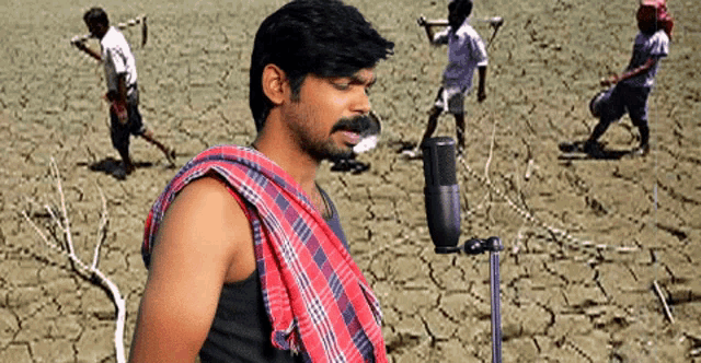 a man singing into a microphone with a plaid towel around his neck