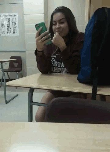 a girl sitting at a desk wearing a sweatshirt that says ' usta ' on it