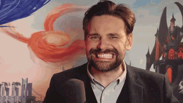 a man with a beard is smiling in front of a castle