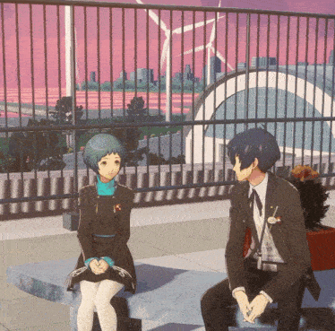 a man and a woman are sitting on a bench in front of a windmill