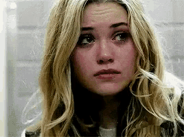 a close up of a woman 's face with a tear coming out of her eye .