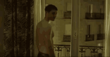 a man without a shirt is standing next to a woman wrapped in a blanket