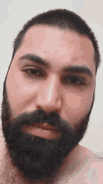 a close up of a man 's face with a beard and short hair