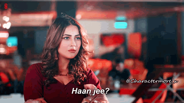 a woman sitting at a table with the words haan jee written below her