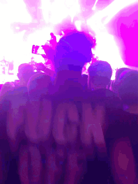 a crowd of people watching a concert with the word hugh on the back