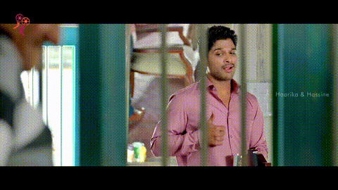 a man in a pink shirt is standing behind bars with his hands on his chest