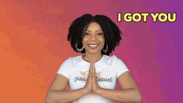 a woman wearing a white t-shirt with the words `` i got you '' on it is pointing at herself .