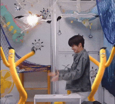 a man is standing in a room with a bunch of stuffed animals