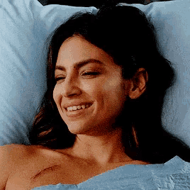 a woman is smiling in a hospital bed with a scar on her chest