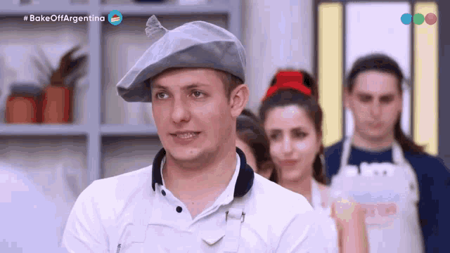 a man wearing a beret stands in front of a group of people with the words bake off argentina on the bottom left