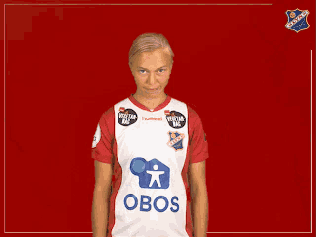 a woman wearing a red and white jersey with the word obos on the front