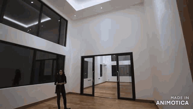 a woman is standing in an empty room with the words made in animatica on the bottom