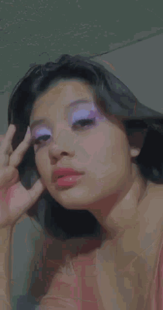 a close up of a woman 's face with purple and white eyeshadow .