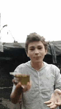 a young boy is holding a box of cigarettes in his hands