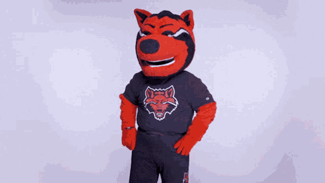 a mascot wearing a black shirt with a red wolf logo on it