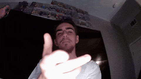 a man giving the middle finger in front of a wall of funko pop figures