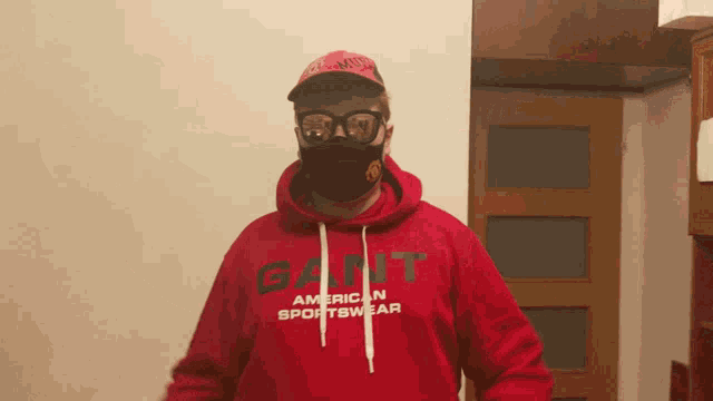 a man wearing a red hoodie that says gant on it