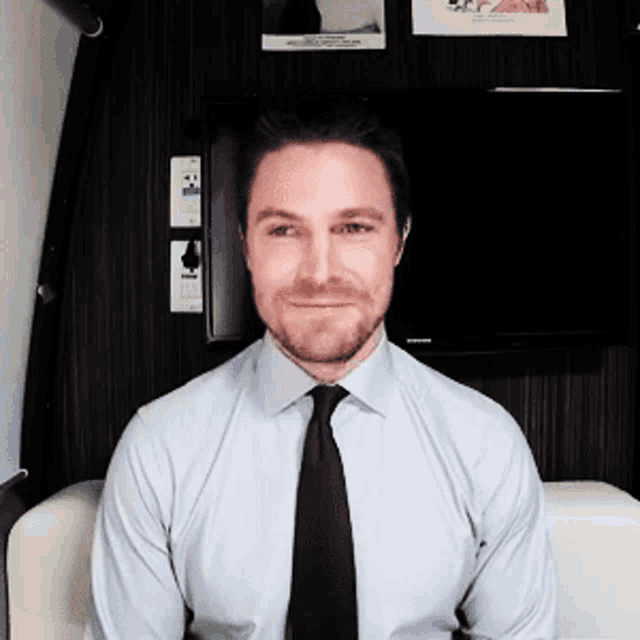 a man with a beard wearing a white shirt and black tie
