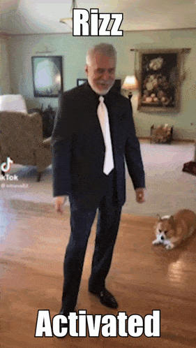 a man in a suit and tie is standing in a living room with a dog behind him and the caption rizz activated