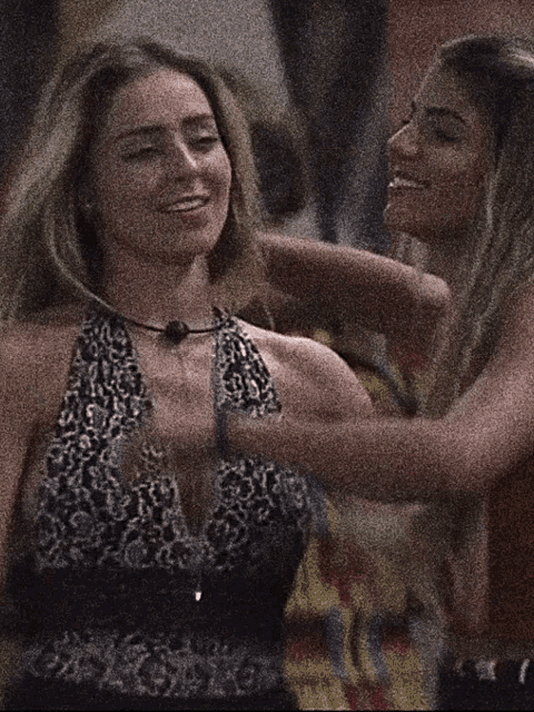 two women are standing next to each other and one has a leopard print top on