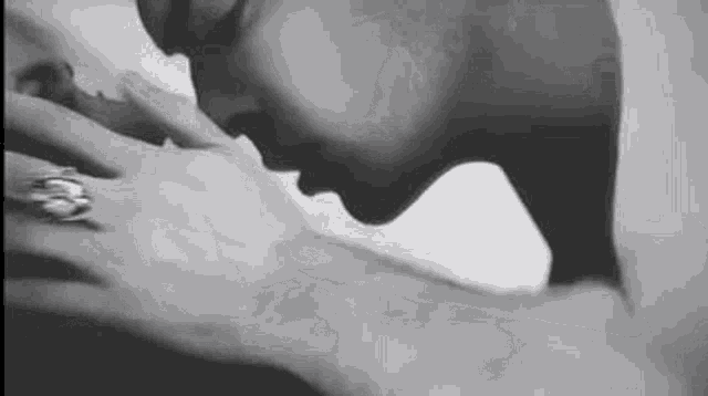 a man and woman are kissing in a black and white photo .