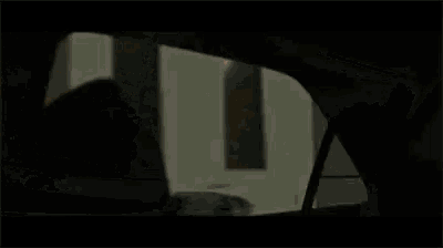 a man is getting out of a car in a dark room .