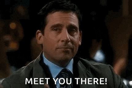 a man in a suit and tie is holding a drink in his hand and says `` meet you there '' .