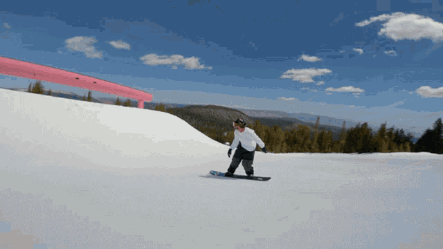 a person on a snowboard going down a snow covered slope