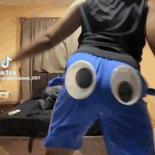 a person wearing blue shorts with googly eyes on the back