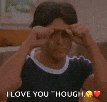 a man is making a heart shape with his hands on his forehead .