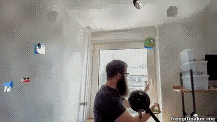 a man with a beard is sitting in front of a microphone in a room with a freegifmaker.me watermark