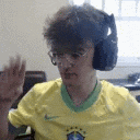 a man wearing headphones and glasses is sitting at a desk .