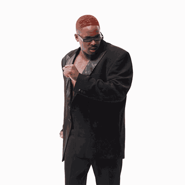 a shirtless man in a black suit has a belt with rhinestones and a cross on it