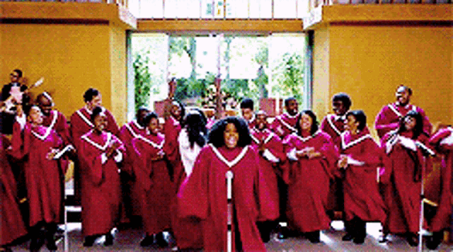 a group of people in red robes are singing and dancing