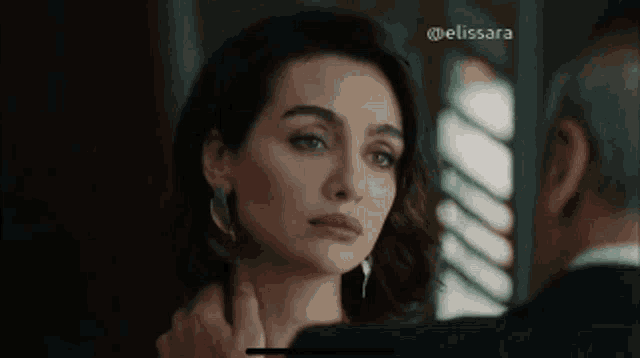a man and a woman are looking at each other in a room .