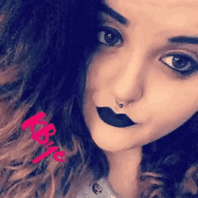 a close up of a woman 's face with a nose ring and black lipstick with the name katie on the bottom