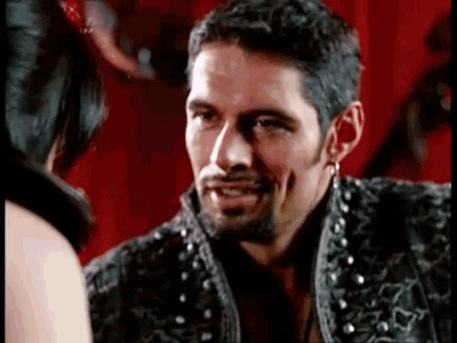 a man with a beard is talking to a woman in a black jacket .