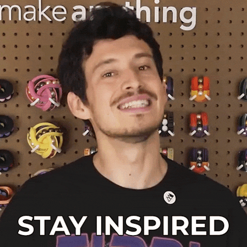 a man wearing a black shirt with the words stay inspired on it