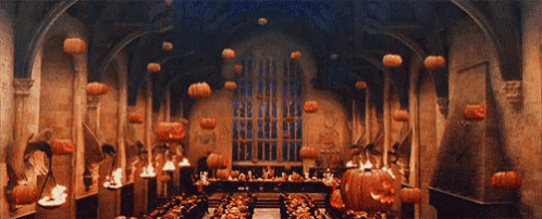 a large room with pumpkins hanging from the ceiling and tables