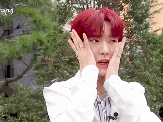 a man with red hair is covering his face with his hands and the word korea is on the bottom
