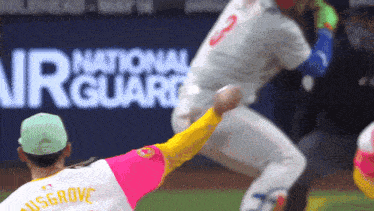 a baseball player in a pink and yellow jersey with the name ausgrove on the back