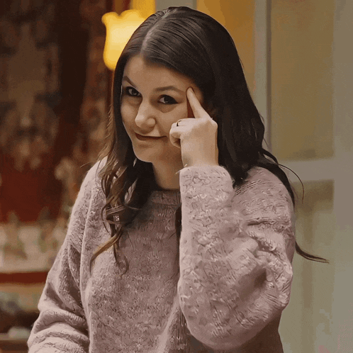 a woman in a purple sweater is making a funny face