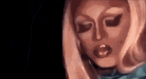 a close up of a woman 's face with makeup on it and a black background .