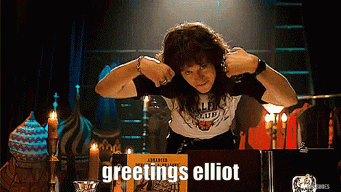 a man sitting in front of a box that says greetings elliot on it