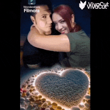 a man and woman hugging with a heart made out of rocks