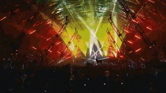 a crowd of people watching a concert with lots of lights and smoke