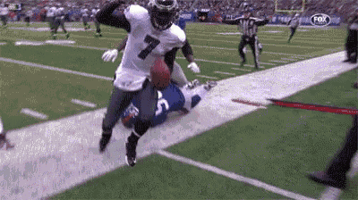 a football player with the number 7 on his jersey is running on a field .
